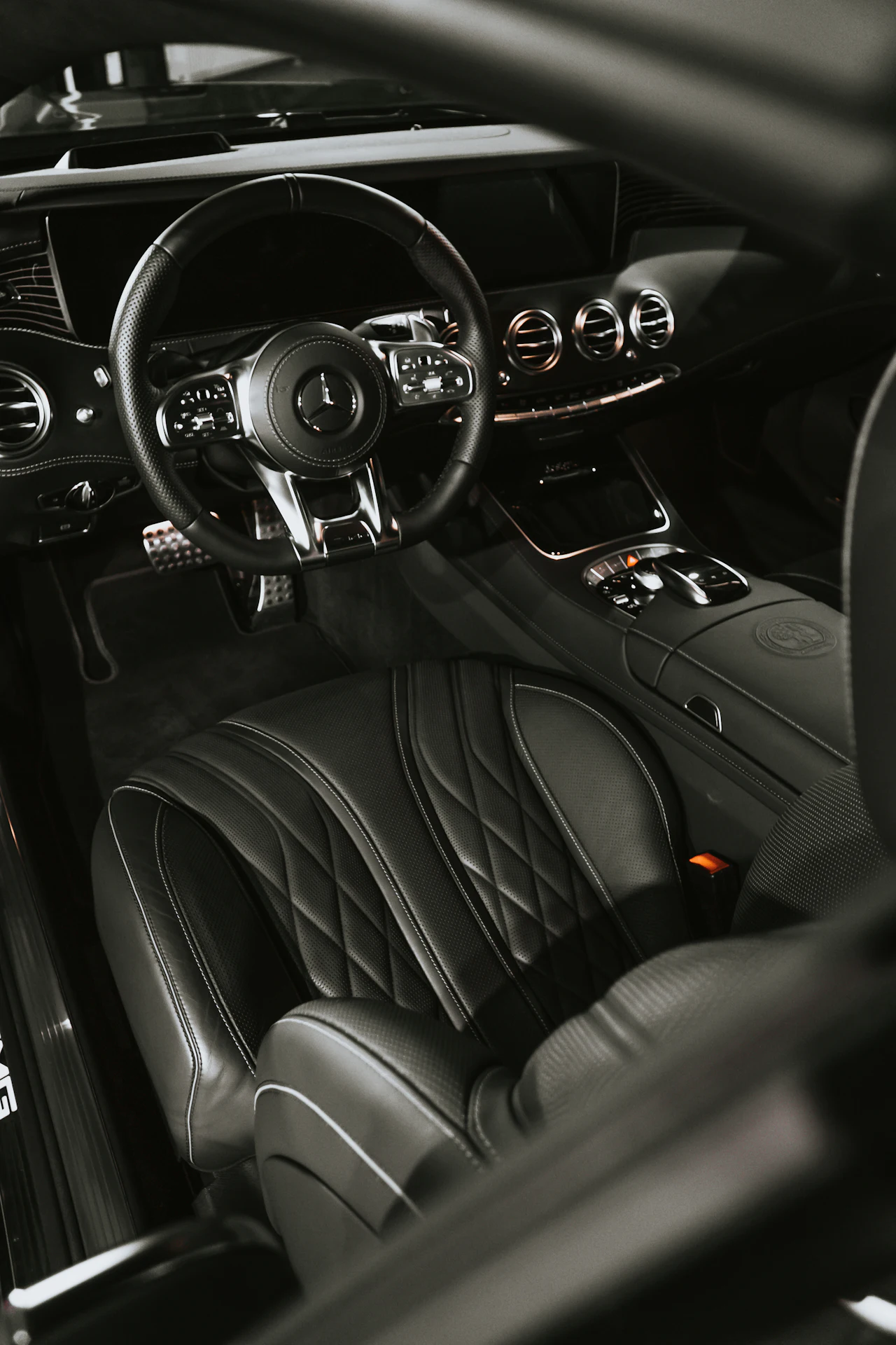 Interior de carro com bancos de couro preto e volante esportivo