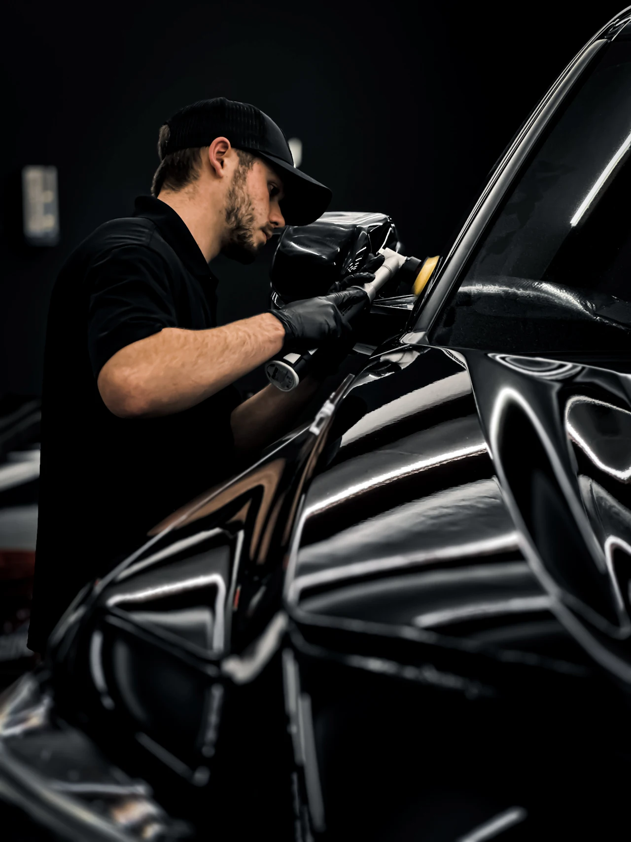 Profissional polindo a lateral de um carro preto com politriz